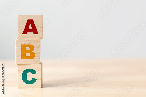 ABC letters alphabet on wooden cube blocks in pillar form on wood table photo