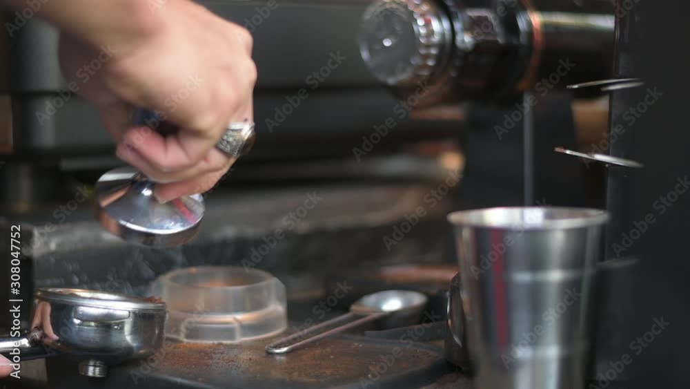 Hand pressing tamper with ground coffee for making hot drink Hand pressing tamper with ground coffee for making hot drink