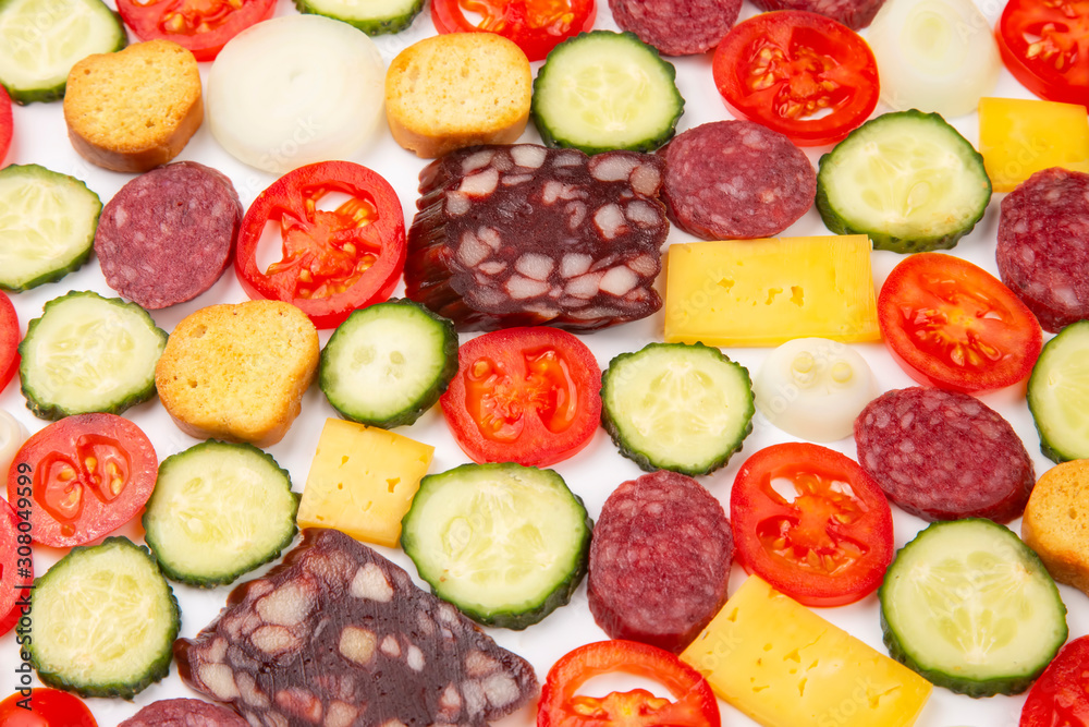 sliced pieces of sausage, salami, cheese, cucumber and tomato. fast food. ingredients for pizza. calories and diet sliced pieces of sausage, salami, cheese, cucumber and tomato. fast food. ingredients for pizza. calories and diet