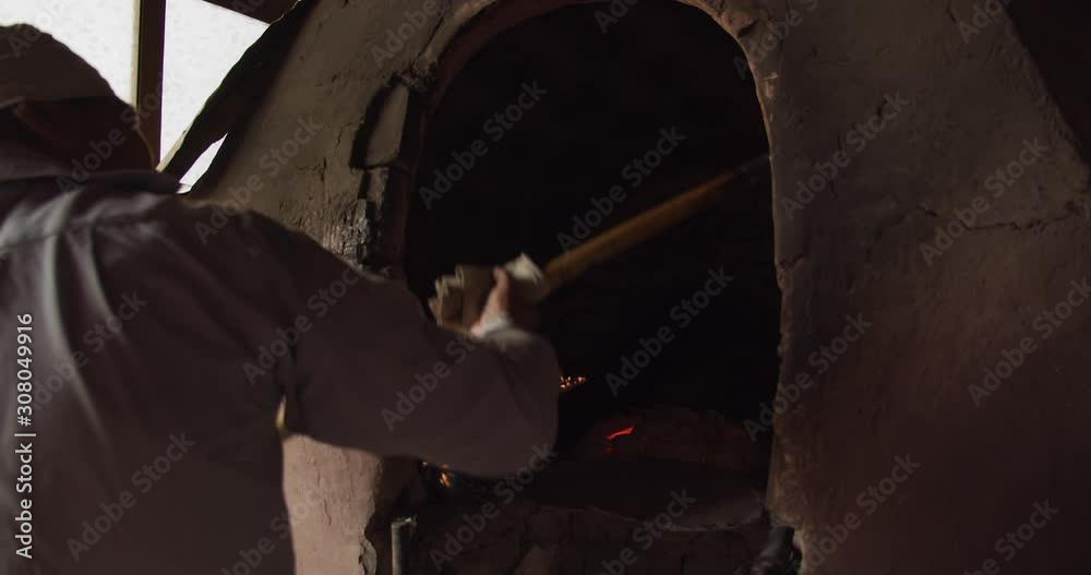 A man lays a lepeshka bread in a tandoor stove. Margilan city, Uzbekistan, Central Asia A man lays a lepeshka bread in a tandoor stove. Margilan city, Uzbekistan, Central Asia