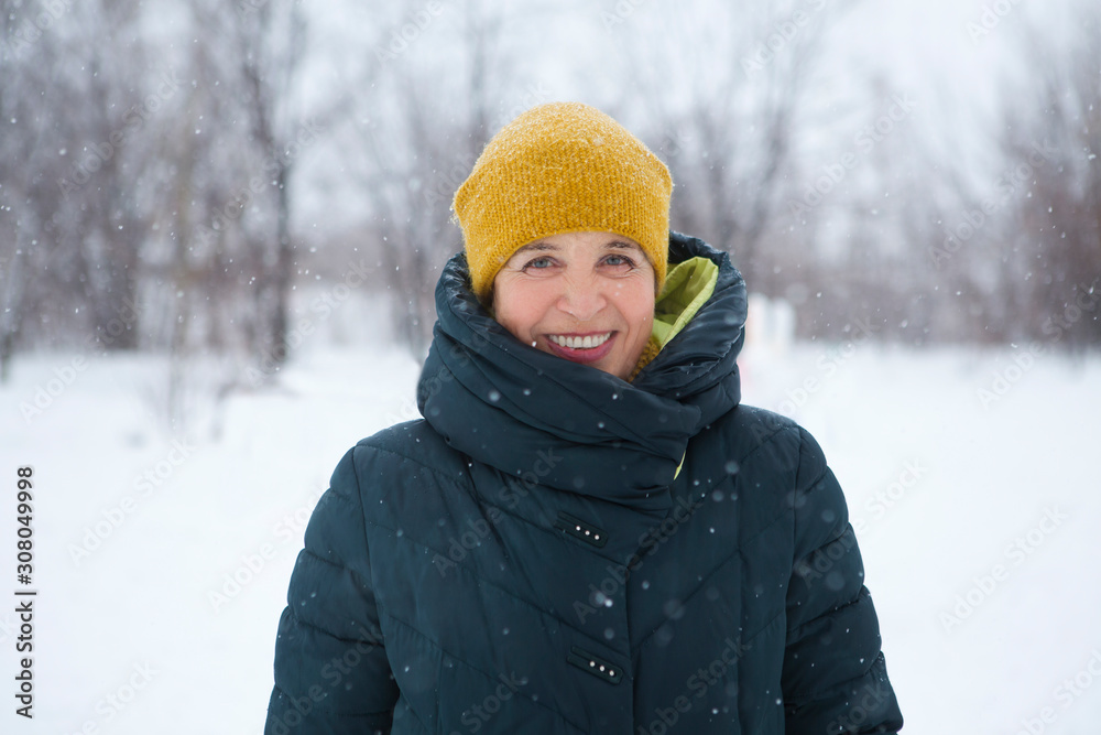 Portrait of smiling senior woman. Grandmom in snowy outdoors. Portrait of smiling senior woman. Grandmom in snowy outdoors.
