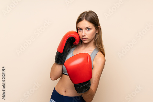 Young blonde girl with boxing gloves over isolated background