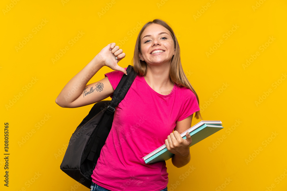 Young student girl over isolated yellow background proud and self-satisfied Young student girl over isolated yellow background proud and self-satisfied