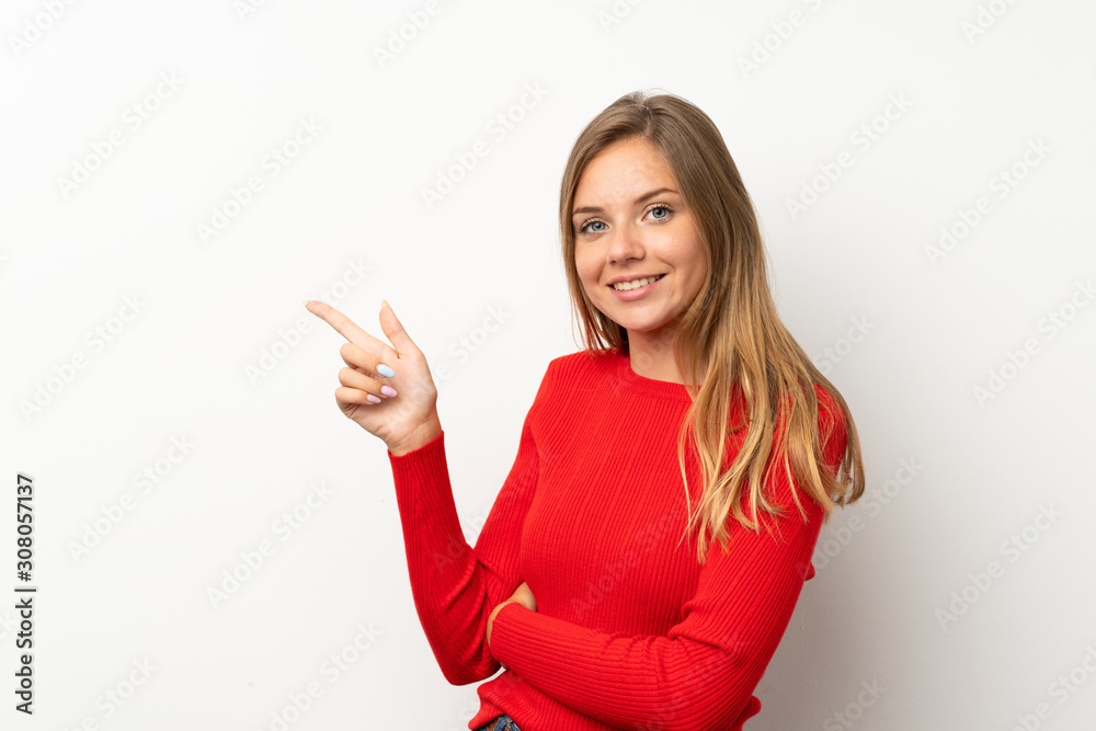 Young blonde woman with red sweater over isolated white background pointing finger to the side Young blonde woman with red sweater over isolated white background pointing finger to the side