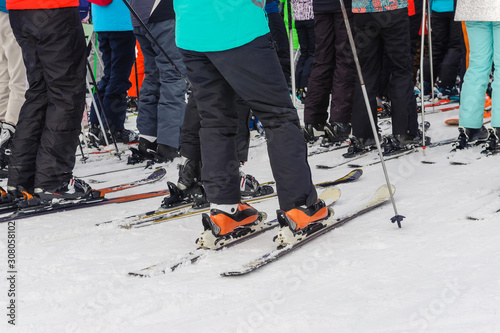 Skiers, adults and children, stand in line for the lift: the concept is a popular sport, crowded on weekends.