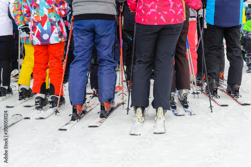 Skiers, adults and children, stand in line for the lift: the concept is a popular sport, crowded on weekends.