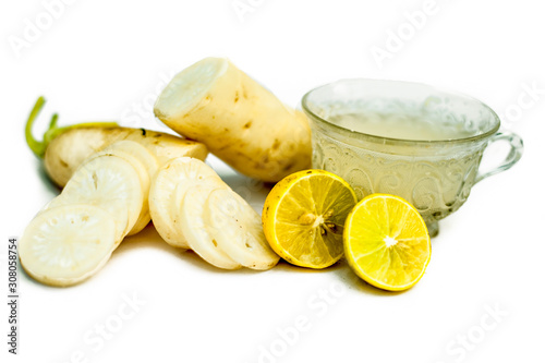 Detoxifying Daikon radish tea in a transparent glass cup isolated on a white background.Horizontal shot of colorless and odorless daikon tea in a cup. It supports to body's antioxidant activity. photo