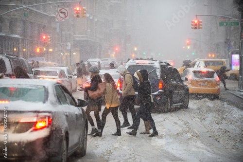 Winter blizzard on the streets of New York City with traffic clogged and cold pedestrians 