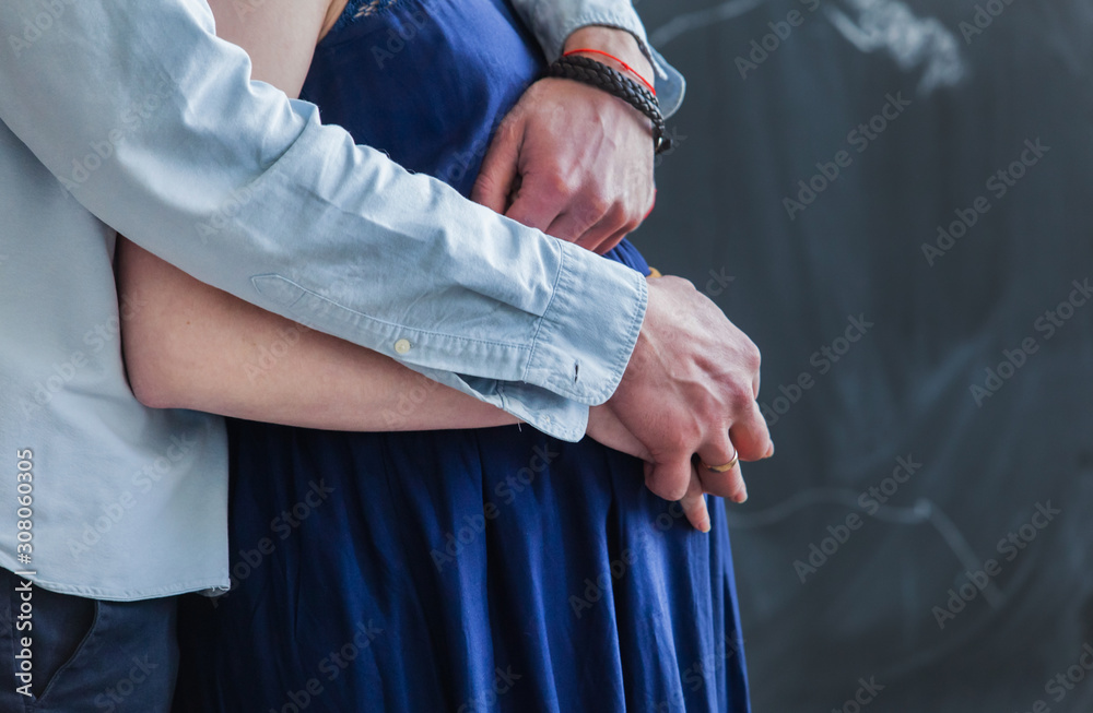 Man embraces his pregnant woman