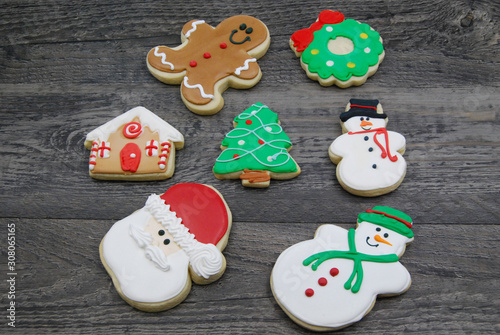 Decorated, Iced Christmas Cookies rabdomly layed out on rustic wood