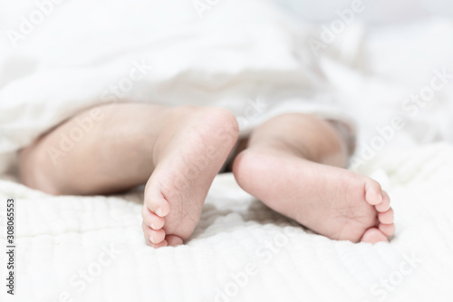 Newborn baby feet on a white blanket.