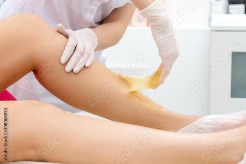 beautician hair removal procedure on the client's feet in beauty parlor © ukka63