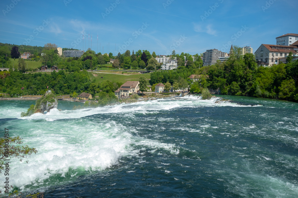 Beautiful view of Rhein fall with fresh green trees and clear blue sky for background with copy space , Switzerland