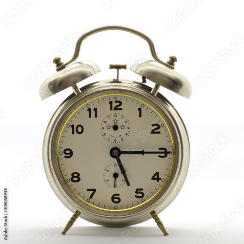 Old-style alarm clock, metal, it's quarter past five.