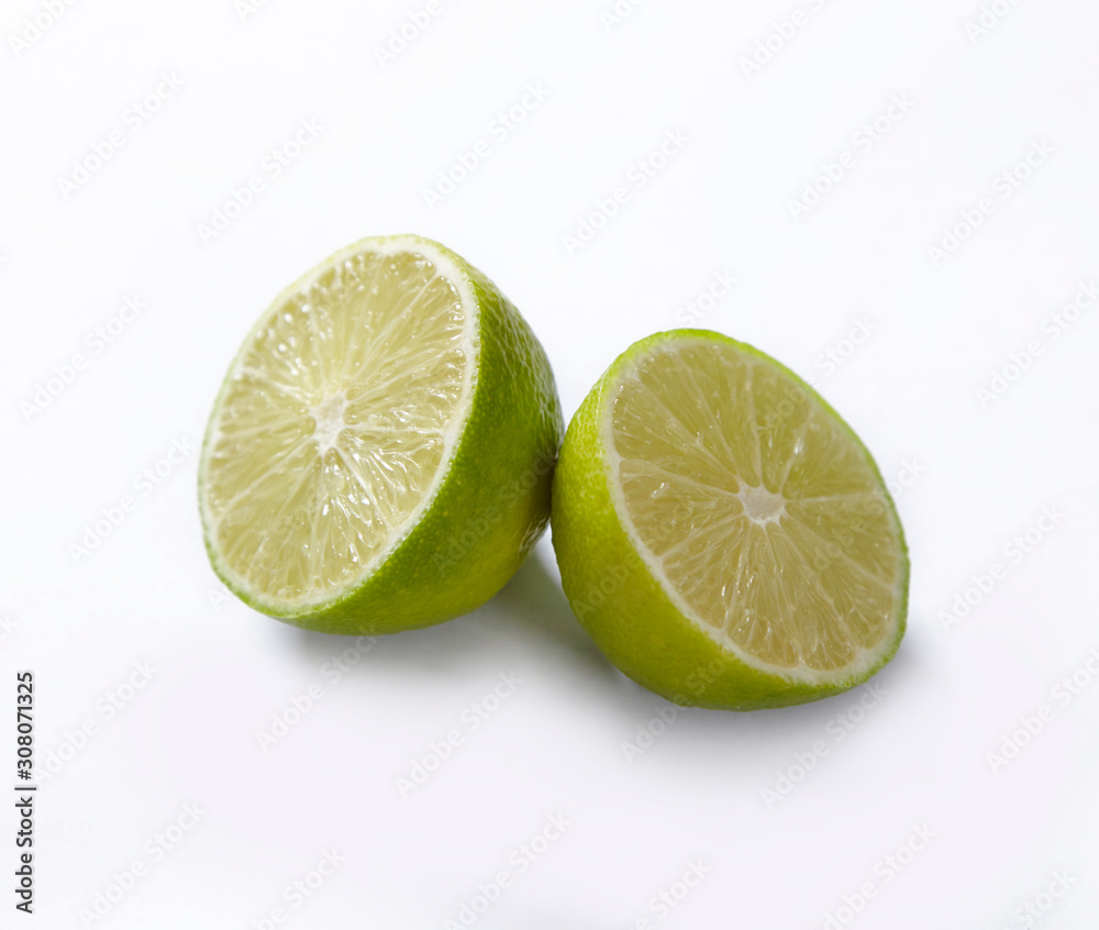 Natural fresh lime with water drops and slice of green lime citrus fruit stand isolated on white background.