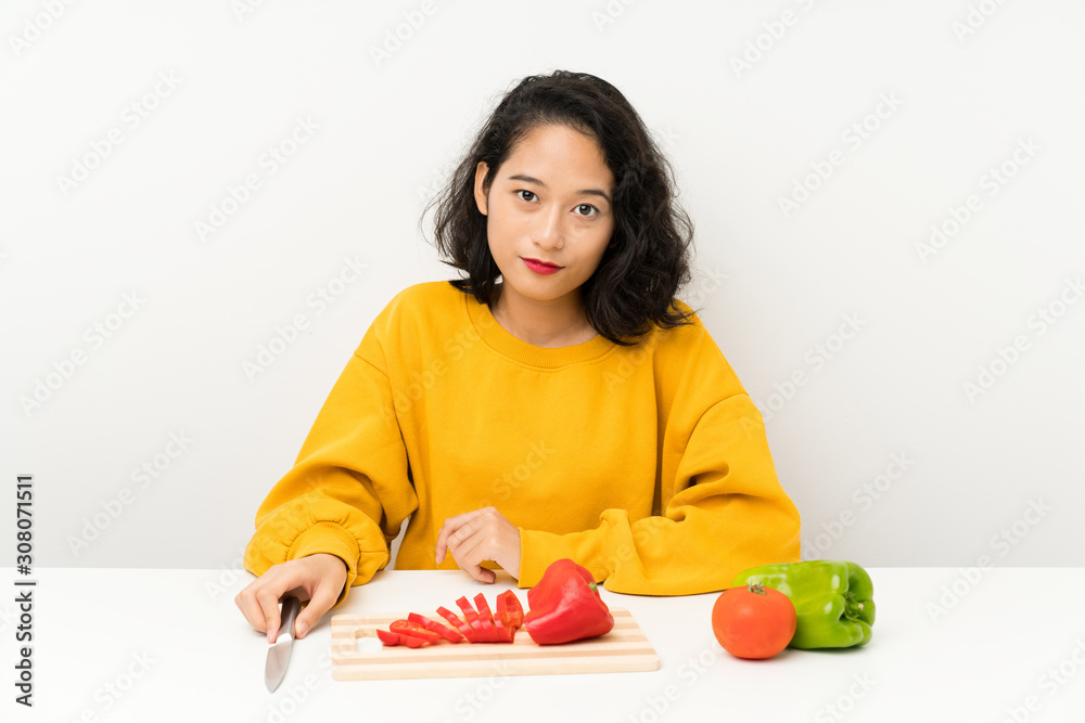 Young asian girl with vegetables in a table Young asian girl with vegetables in a table