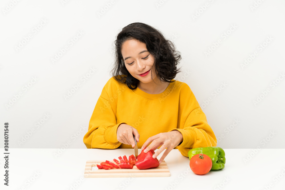 Young asian girl with vegetables in a table Young asian girl with vegetables in a table