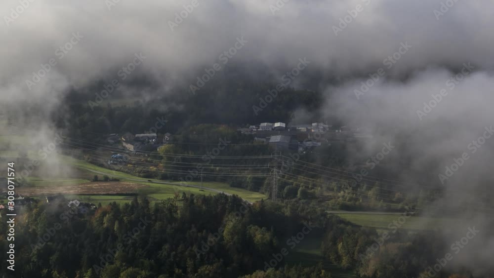 Time lapse looking down village gets covered by low altitude cloud fog