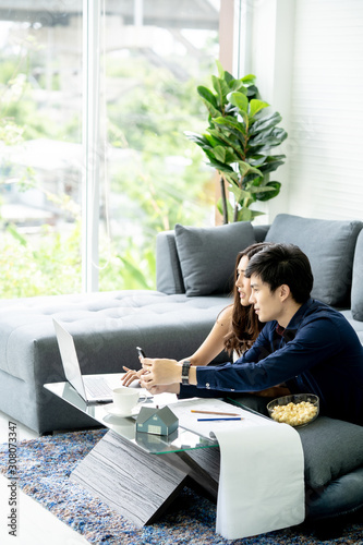 Young Asian Adult Couple Planning New Home Design.