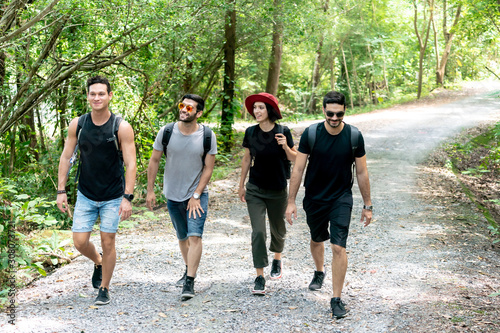 Group Of Friends hiking together through the forest