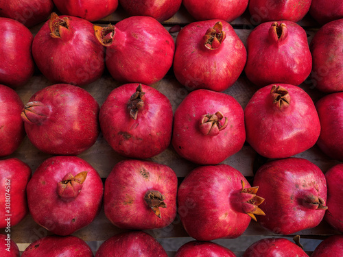 Red ripe pomegranate fruit lie in a box