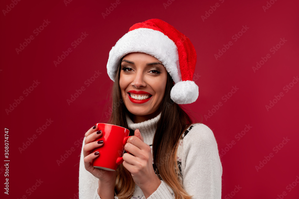 Close up portrait beautifiul caucasian woman in red Santa hat on red studio background. Christmas and New Year holiday concept. Close up portrait beautifiul caucasian woman in red Santa hat on red studio background. Christmas and New Year holiday concept.