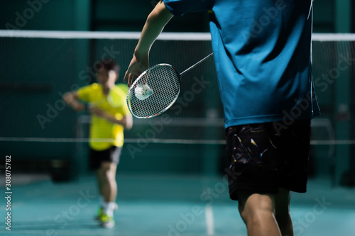 Asian badminton player is hitting in court