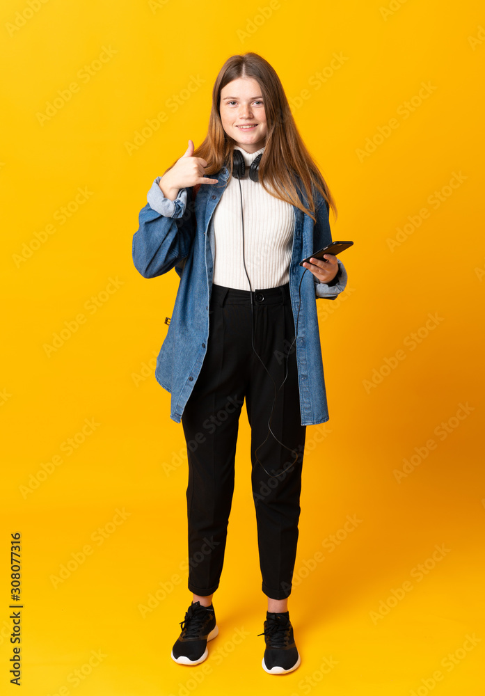 Student ukrainian teenager girl over isolated yellow background making phone gesture Student ukrainian teenager girl over isolated yellow background making phone gesture