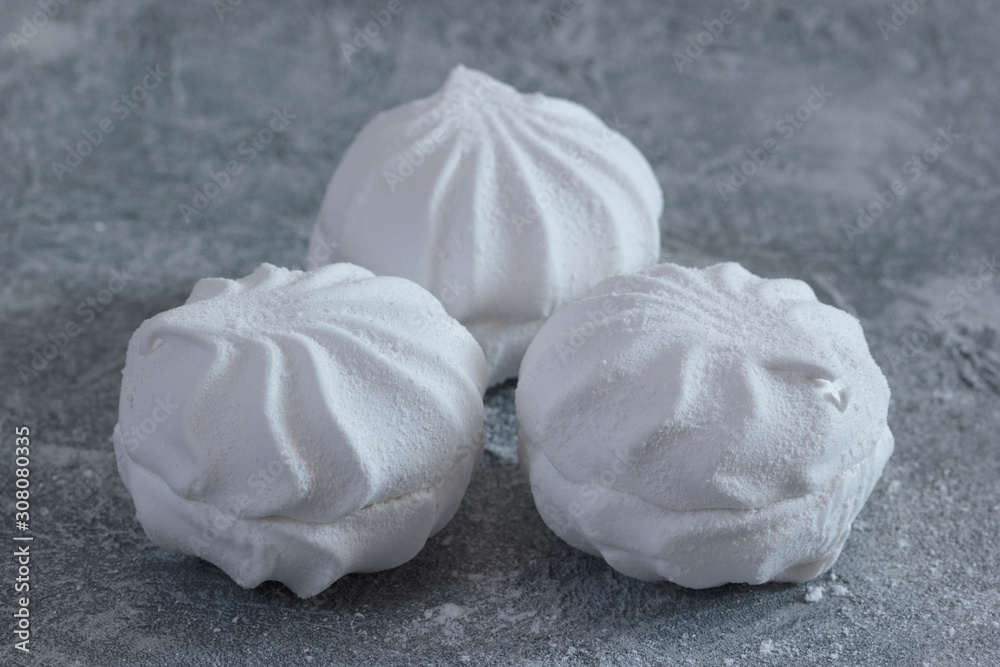 Obraz premium White zephyr or zefir sweet cakes. Cooked from eggs protein, agar, natural applesauce pectin and sugar powder by mixing and baking. Soft, sweet and airy dessert.