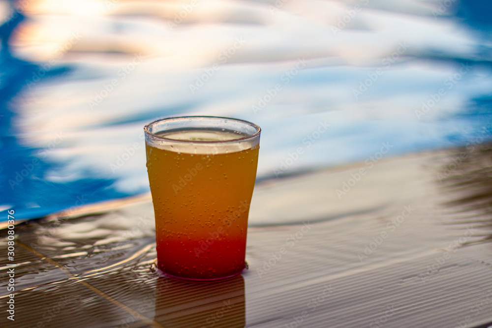 Colorful cocktail on the edge of a bright blue pool. Colorful cocktail on the edge of a bright blue pool.