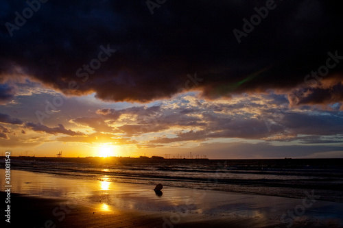 Reflecting sunset on a sandy beach.