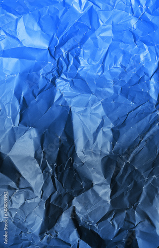 Photo of crumpled paper texture in classic blue color. Color of the year 2020.