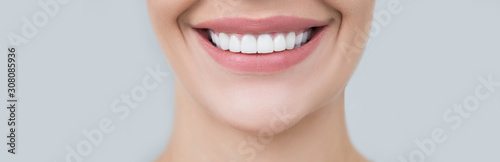 Perfect female smile on gray background. Healthy white teeth, advertising dentistry photo