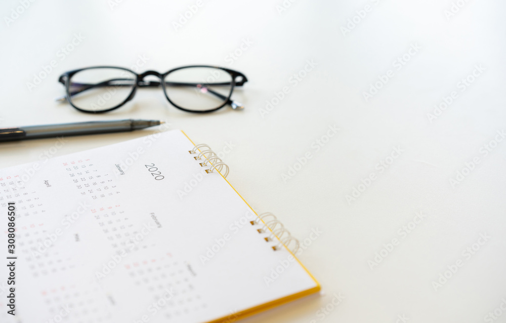 close up side view on white calendar schedule background with pen and eyeglasses to make appointment meeting or manage timetable each day for planning work in new year 2020 resolution concept close up side view on white calendar schedule background with pen and eyeglasses to make appointment meeting or manage timetable each day for planning work in new year 2020 resolution concept
