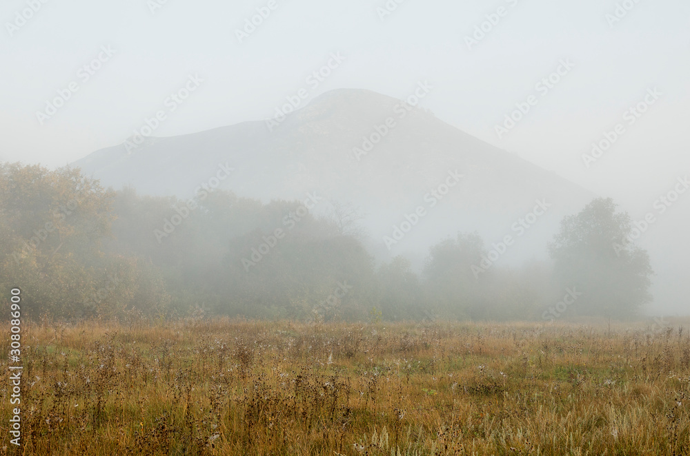 The remain of the reef of the ancient sea - solitary mountain Yuraktau in morning mist.