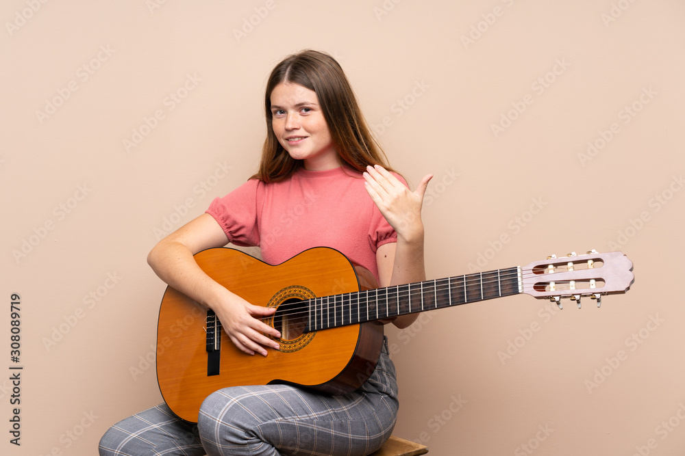 Ukrainian teenager girl with guitar over isolated background inviting to come with hand. Happy that you came Ukrainian teenager girl with guitar over isolated background inviting to come with hand. Happy that you came