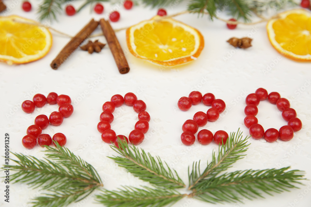 Christmas or New Year composition, background 2020 with cinnamon, red berries, orange, star anise. Card, Background.