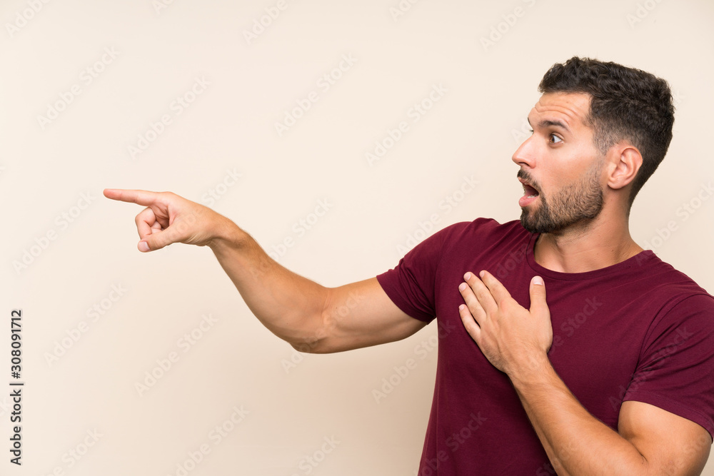 Handsome man over isolated background pointing finger to the side Handsome man over isolated background pointing finger to the side