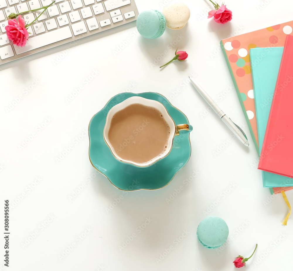 Flat lay women's office desk. Female workspace with laptop, flowers roses,  accessories, notebooks, cup of coffee on white background. Top view feminine background.