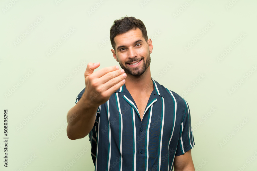 Handsome man over isolated background inviting to come Handsome man over isolated background inviting to come
