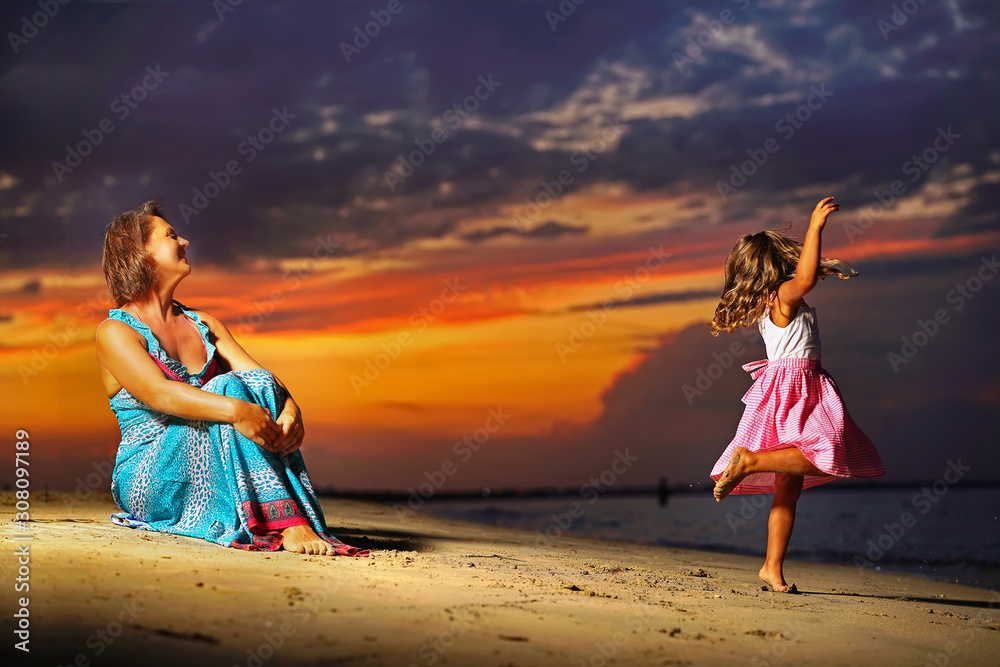 mother and daughter at sea with sunset mother and daughter at sea with sunset