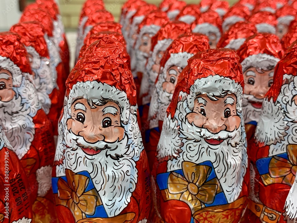 Chocolates in the form of Santa Claus. Christmas sweets on a supermarket shelf. A lot of bright toys: Santa Claus. Gifts for children for the new year.
