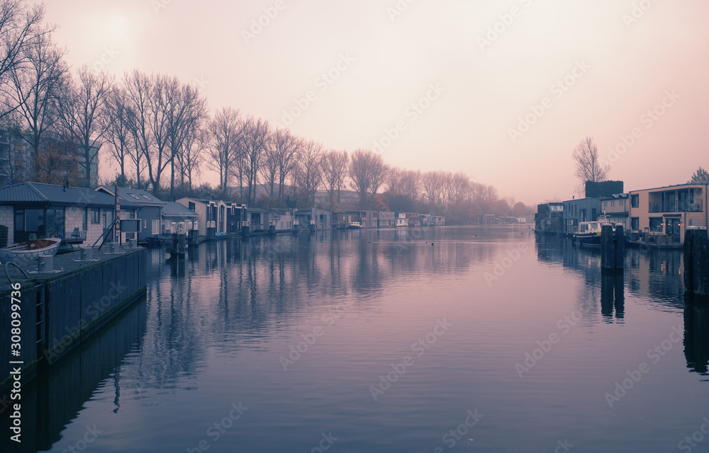 Pink sunrise over living boats in Amsterdam