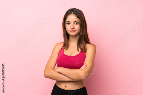 Young sport girl over isolated pink background keeping the arms crossed