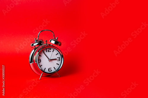 Metal Alarm clock on red background , isolated 