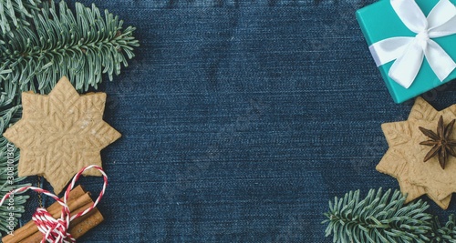 Christmas layout, spruce branches, homemade ginger cookies, bunch of cinnamon sticks, blue gift box, top view.