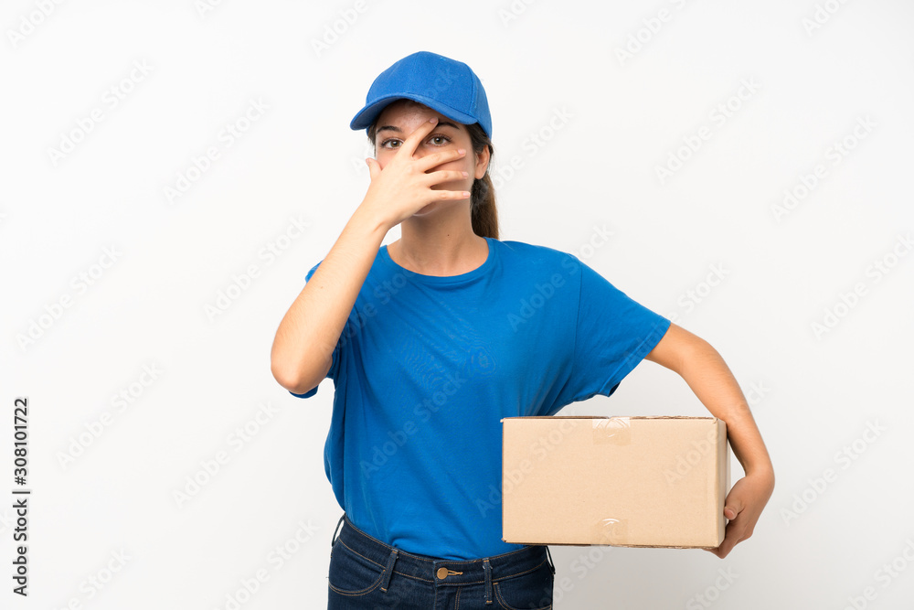 Young delivery girl over isolated white background covering eyes and looking through fingers Young delivery girl over isolated white background covering eyes and looking through fingers