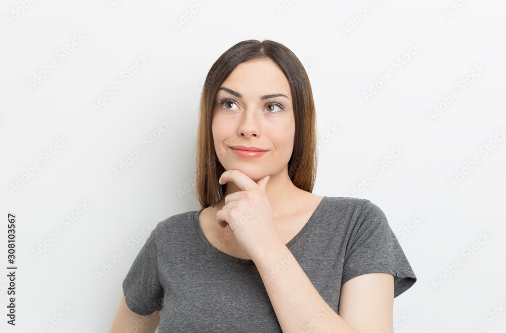 Beautiful young woman thinking about an idea. Portrait of a pensive girl on a white background. Beautiful young woman thinking about an idea. Portrait of a pensive girl on a white background.