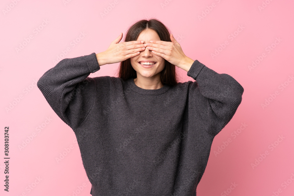Young woman over isolated pink background covering eyes by hands Young woman over isolated pink background covering eyes by hands