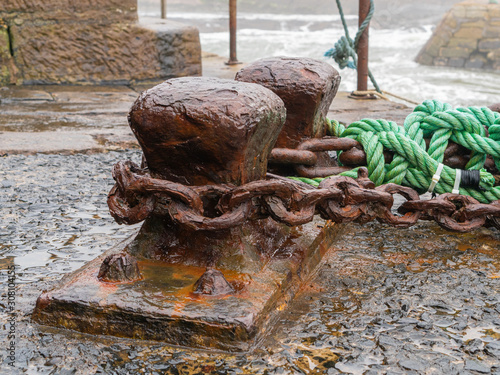 Rusty harbour cleats, chains and ropes